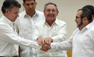 Le président colombien Juan Manuel Santos (g) et le chef des FARC Timoleon Jimenez alias Timochenko (d) se serrent la main devant le président cubain Raul Castro, le 23 septembre 2015 à La Havane