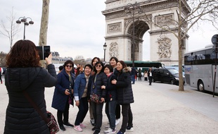 Un groupe de touristes chinois devant l'Arc de Triomphe à Paris.