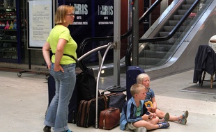 Une famille attend son train pour partir en vacances
