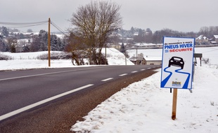 Illustration d'un panneau indiquant route glissante et la sensibilisation à mettre des pneus hiver.