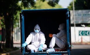 Des hommes vêtus d'équipements protecteurs à New Delhi, le 4 mai 2020.