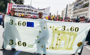 Des manifestants portent une bannière représentant un billet en euros parodique, lors d'une manifestation le 7 avril 2016 à Athènes