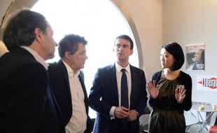 Le Premier ministre Manuel Valls (c), la ministre de la Culture Fleur Pellerin (d) et le chroniqueur de Charlie Hebdo Patrick Pelloux (2e g) au siège de Libération à Paris le 9 janvier 2015