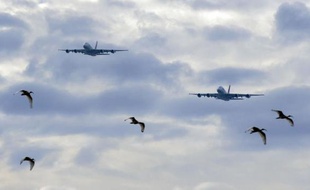 Deux Airbus A380 ont survolé dimanche en tandem le célèbre pont franchissant le port de Sydney pour marquer le début de l'alliance entre Qantas et Emirates, élément clé dans la stratégie de la compagnie australienne pour sortir de ses difficultés financières.
