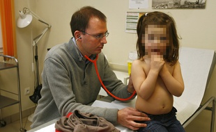 Un médecin généraliste ausculte une petite fille dans son cabinet.