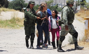 Des membres de la garde nationale mexicaine arrêtent des migrants qui tentaient de franchir le Rio Bravo, à Ciudad Juarez.