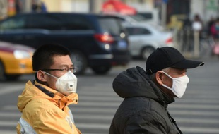 Deux Chinois portent des masques anti-pollution à Pékin le 19 décembre 2015