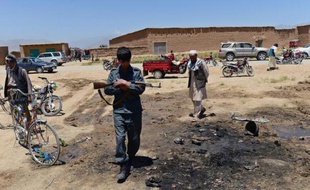 Un policier afghan sur le site d'un attentat-suicide qui a fait 16 morts dont 10 civils, le 8 juillet 2014 dans la région de Parwan