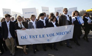 Ghyslain Wattrelos (3e à d), proche de victimes du vol MH370 de la Malaysia Airlines qui a disparu en mars 2014, en tête d'une marche silencieuse vers le Palais de l'Elysée à Paris, le 8 mars 2015