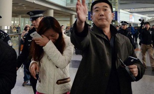 Une femme dont le proche est porté disparu dans le Boeing 777-200 de Malaysia Airlines pleure à l'aéroport de Pékin le 8 mars 2014