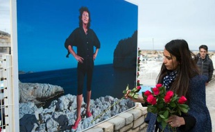 Une personne dépose des fleurs sous le portrait de Florence Arthaud à Marseille, le 14 mars 2015