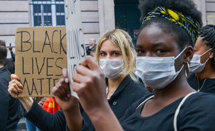 Des manifestants à Paris, pour dénoncer les violences policières en France, brandissant des pancartes Black Lives Matter.