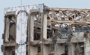 Des travailleurs en combinaison intégrale s'activent au milieu de bâtiments éventrés, l'oeil sur des dosimètres. La centrale accidentée de Fukushima livre une image de désolation aux rares visiteurs étrangers autorisés sur le site.