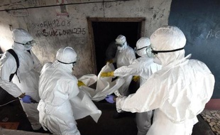 Des membres de la Croix rouge s'apprêtent à emmener le corps d'un homme mort probablement du virus Ebola, à Monrovia, dans la capitale du Liberia, le 4 octobre 2014