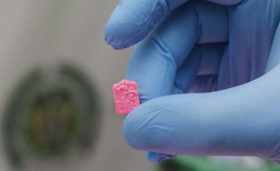 Un policier présente un comprimé de MDMA saisi à l'aéroport de Bogota en Colombie.