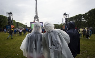 Des supporteurs de football affrontent la pluie dans la «fan-zone» de Paris le 12 juin 2016.