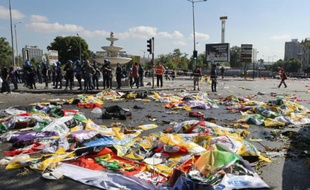 Des policiers autour des corps de victimes, recouverts de drapeaux, du double attentat qui a fait au moins 86 morts à Ankara en Turquie, le 10 octobre 2015