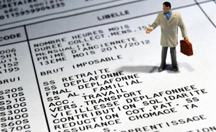 Photo d'une figurine posée sur un bulletin de salaire