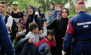 La police bloque un groupe de migrants après leur départ d'un "point de rassemblement", le 9 septembre 2015 près du village de Roszke à la frontière serbo-hongroise
