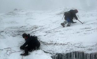 Au sommet du Mont Stanley, dans la chaîne du Rwenzori, à cheval entre l'Ouganda et la République démocratique du Congo (RDC), des alpinistes grimpent dans la neige le 8 mars 2014