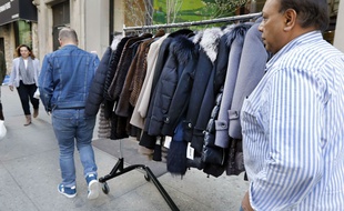 Des hommes transportent des manteaux en fourrure dans les rues de New-York.