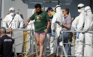 Un homme suspecté d'être un passeur quitte un bateau d ela marine irlandaise à Palerme en Italie, le 6 août 2015