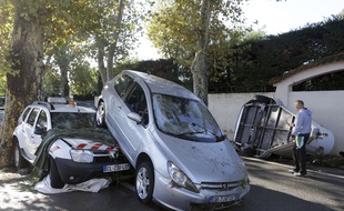 A man walks past damaged cars in Biot, near Cannes, southeastern France, Sunday Oct.4, 2015. Sudden heavy rains around the French Riviera have killed at least 10 people, including some trapped in cars, a campsite and a retirement home, and left six missing. Car and train traffic was disrupted along the Mediterranean coast. (AP Photo/Lionel Cironneau)/NIC103/774647984835/1510041138
