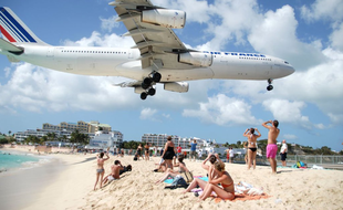 Les avions frôlent les touristes sur la plage de Maho Beach, à Saint-Martin.