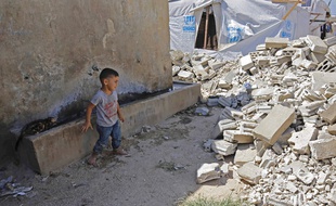 Un enfant syrien regarde les ruines d'un camp de réfugiés au Liban, le 9 août 2019.
