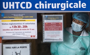 Rennes, le 1er avril. Une femme équipée d'un masque et d'une blouse regarde un patient infecté par le coronavirus à travers une vitre.