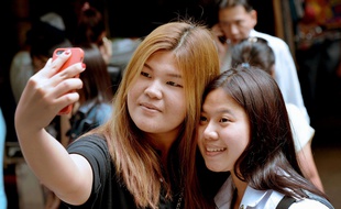 Deux étudiantes font un selfie à Bangkok, en 2014.