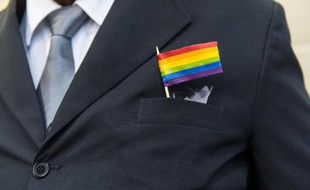 Un drapeau arc-en-ciel sur un costume lors d'un mariage entre deux hommes