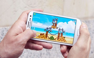 Un homme joue à un jeu sur smartphone.