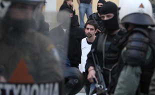 La police grecque escorte l'un des deux hommes soupçonnés d'avoir envoyé des colis piégés aux représentations diplomatiques de différents pays à Athènes, le 2 novembre 2010.