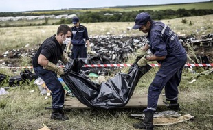 Des secouristes ukrainiens lèvent un corps sur le site du crash du vol MH 17 à Grabove, près de Donetsk en Ukraine le 20 juillet 2014
