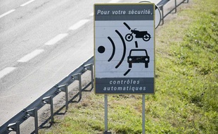Des ouvriers démontent un panneau avertissant de la présence d'un radar, le 16 mai 2011 à Dijon, à la suite d'une des mesures du gouvernement destinée à enrayer la remontée du nombre de morts sur les routes.
