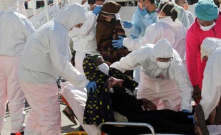 Des migrantes débarquent d'un bateau pour recevoir des soins après une opération de sauvetage, le 15 septembre 2014 à Brindisi, en Sicile