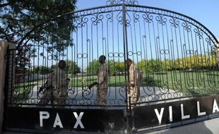 Des policiers devant les grilles de la Villa Pax où est conservé le corps de l'ex-dictateur Jean-Claude Duvalier, le 4 octobre 2014 à Port-au-Prince