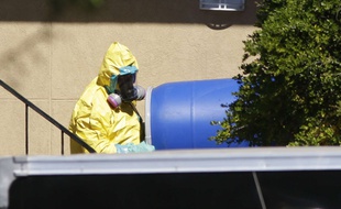Un homme se débarrasse d'un tonneau bleu de l'appartement à Dallas où Thomas Eric Duncan est resté après avoir voyagé du Liberia au Texas, le 3 octobre 2014.