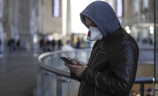 Un homme utilisant son smartphone durant la crise du coronavirus (illustration).