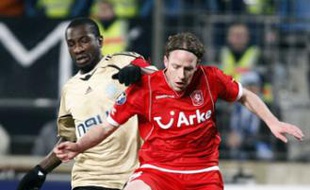 Olympique Marseille's Mamadou Niang (L) challenges Twente's Ron Stan during their UEFA cup soccer match at the Velodrome stadium in Marseille, February 19, 2009. REUTERS/Jean-Paul Pelissier (FRANCE)