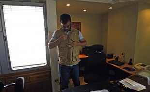 Un homme enfile un gilet pare-balles dans un bureau de Caracas, le 10 octobre 2014 au Venezuela