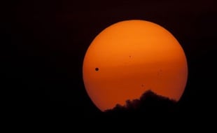 La planète Venus (point noir à gauche) lors de son transit devant le soleil, vue de Katmandou, au Népal, le 6 juin 2012.