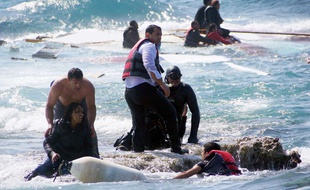 Un homme porte secours à un migrant sur l'île de Rhodes, en Grèce, le 20 avril 2015.