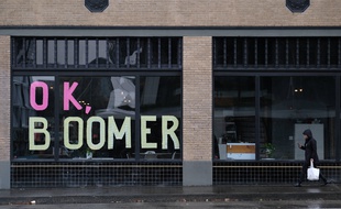 Une femme devant un magasin où est écrit «OK Boomer» à Portland le 12 novembre 2019