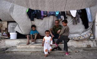 Une famille de migrants afghans, dans le camp de fortune dans l'ancien aéroport de Hellinikon, dans la banlieue balnéaire d'Athènes le 10 mai 2016
