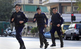 Des policiers grecs s'éloignent du site de l'explosion contrôlée d'un colis suspect découvert dans une société de courrier, près du palais présidentiel à Athènes (Grèce), le 2 novembre 2010.