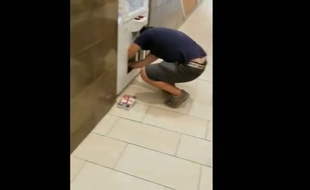 Le jeune père en train de «dévaliser» une machine à pince à l'aide de sa fille