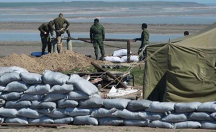 Des soldats russes établissent un point de passage dans le district de Henichesk sur la route de Tchongar l'une des seules routes reliant la Crimée à l'Ukraine