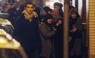 Des femmes en pleurs après l'incendie criminel qui a visé la mosquée chiite du quartier d'Anderlecht, à Bruxelles, en Belgique, lundi 12 mars au soir.